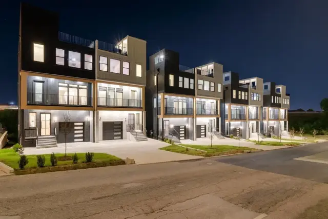 Modern multi-story townhome row at twilight